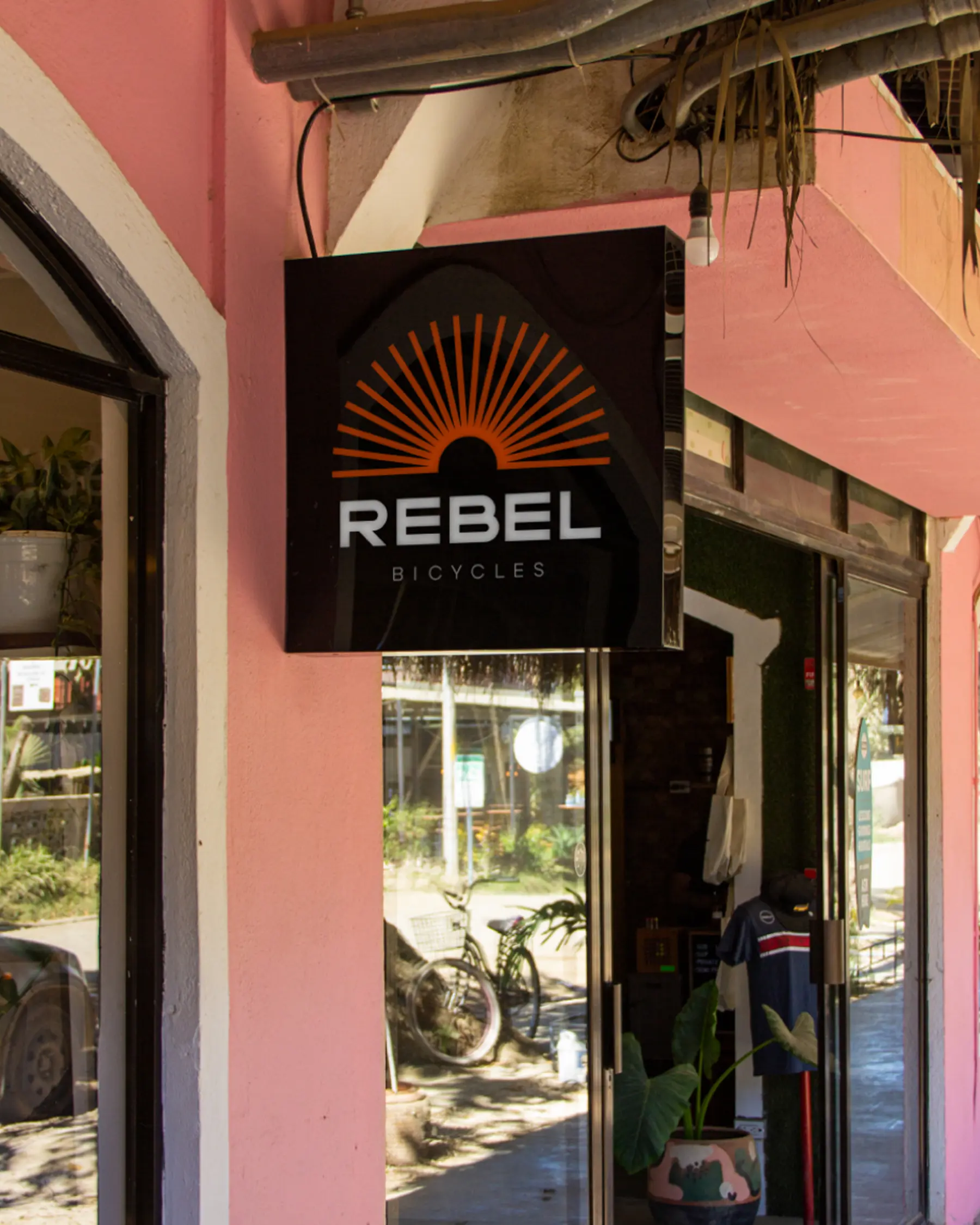 Торцева вивіска з логотипом біля магазину Rebel Bicycles.