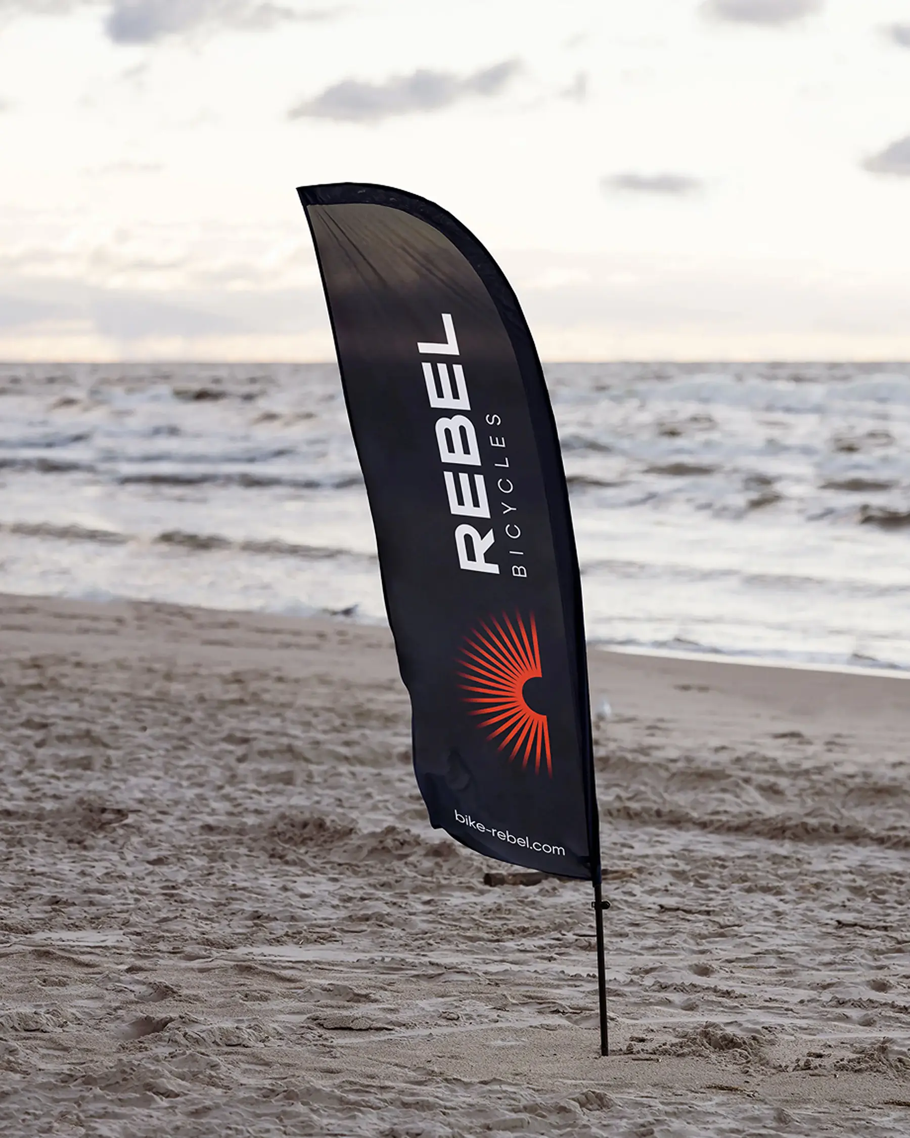 Фірмовий чорний прапор Rebel Bicycles на узбережжі.