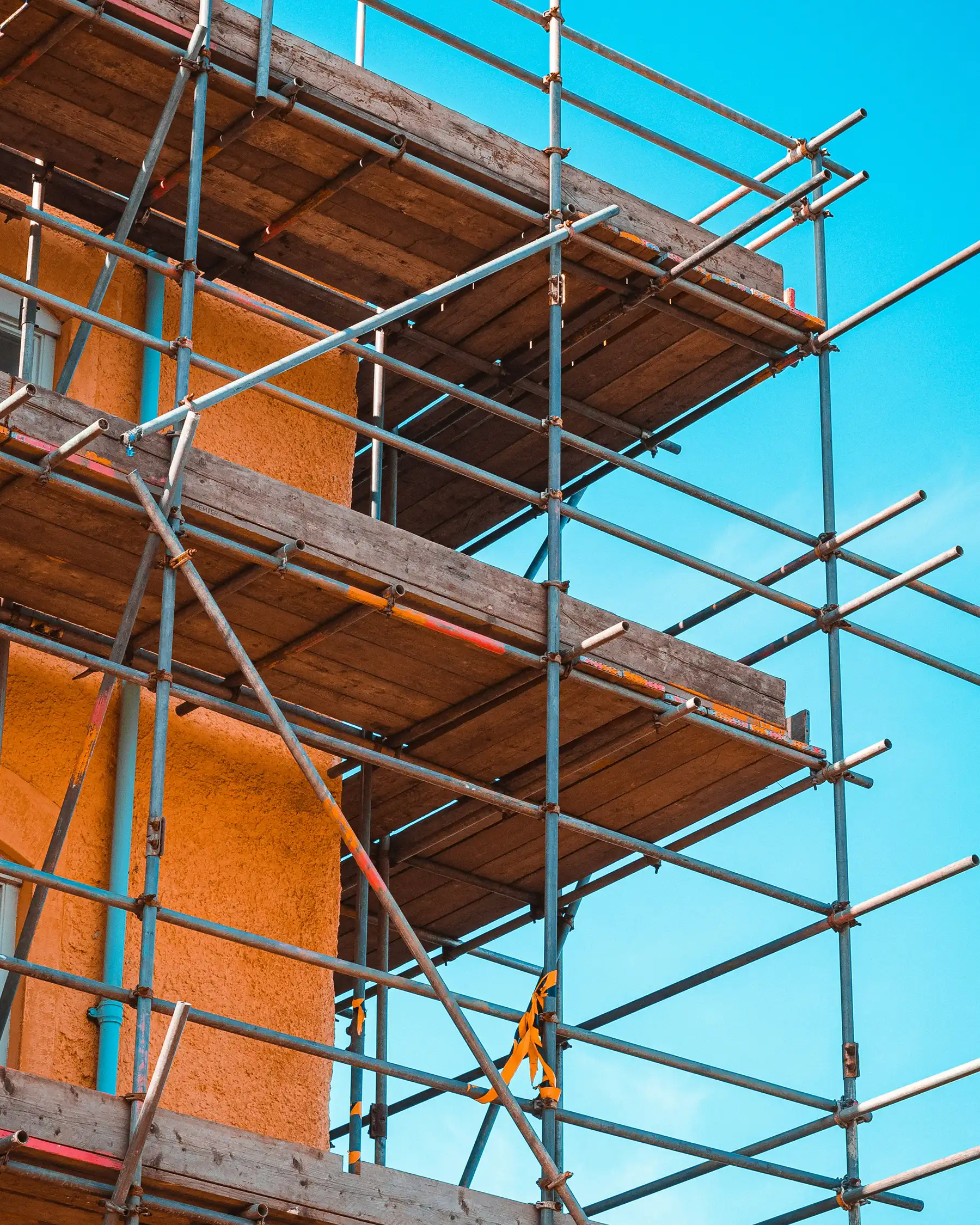 Помаранчева будівля з риштуванням.