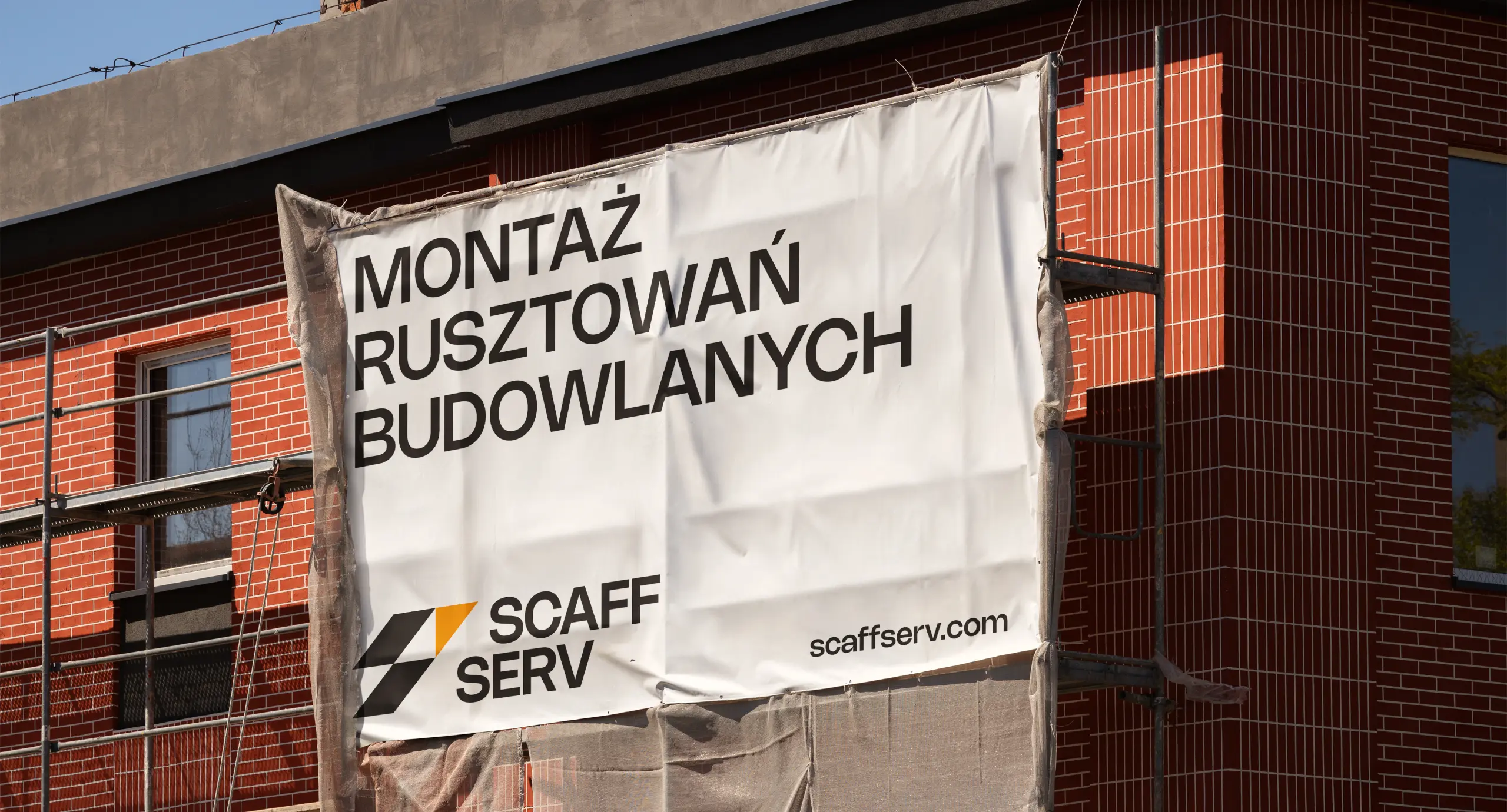 Рекламний банер оновленого бренду Scaff Serv закріплений на риштуваннях будинку
